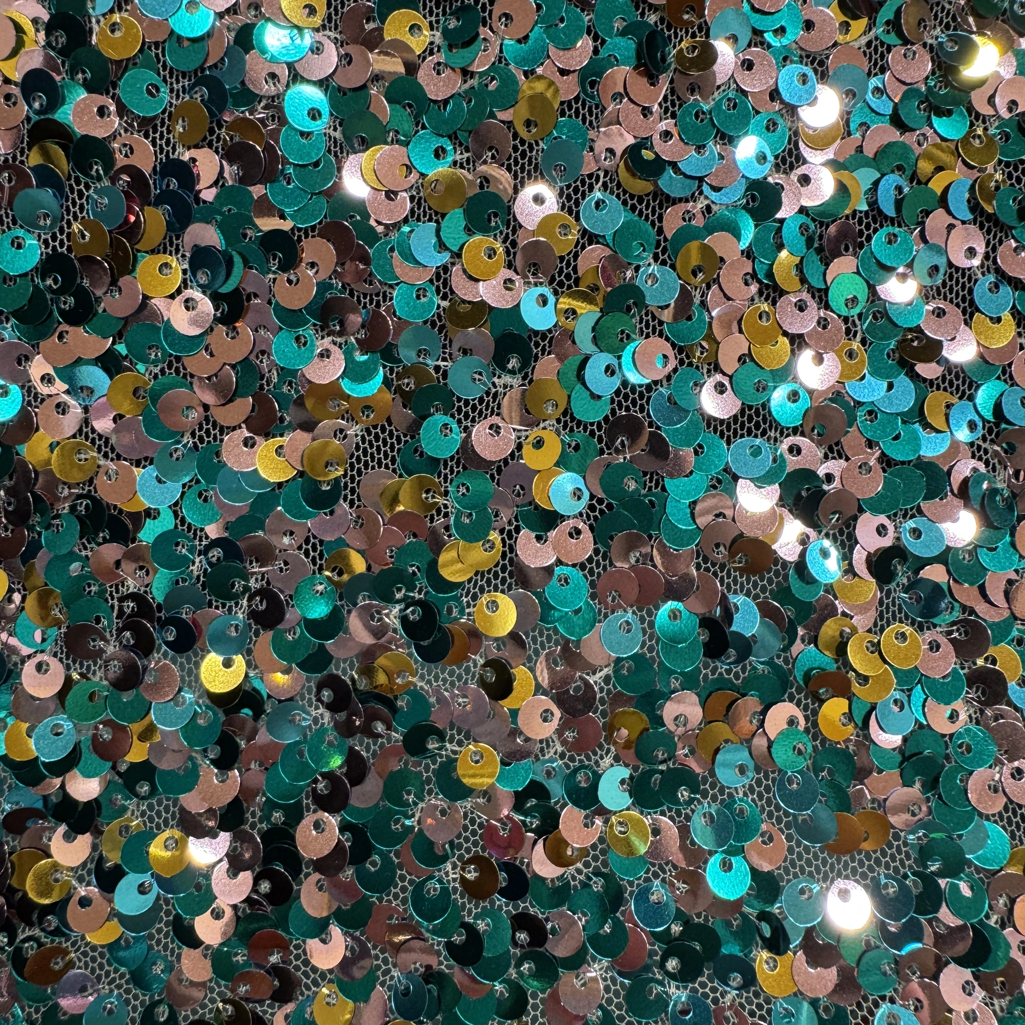 Lentejuelas en verde azulado, rosa y dorado sobre tul oscuro